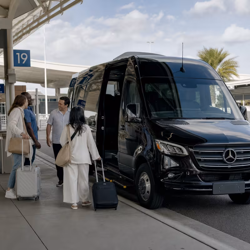 Group boarding a white charter bus for Airport Transportation transportation in Fort Myers
