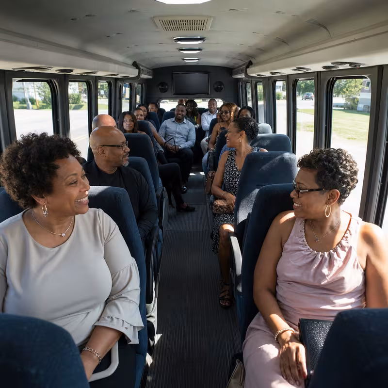 Group boarding a white charter bus for Private Event Transportation transportation in Fort Myers