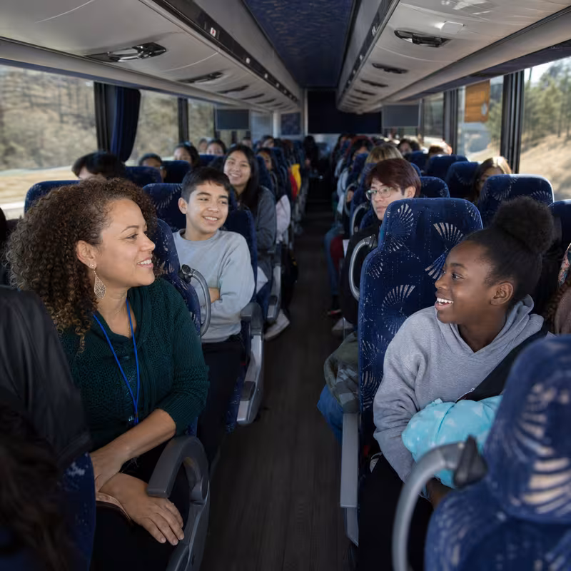 Group boarding a white charter bus for School Transportation transportation in Fort Myers