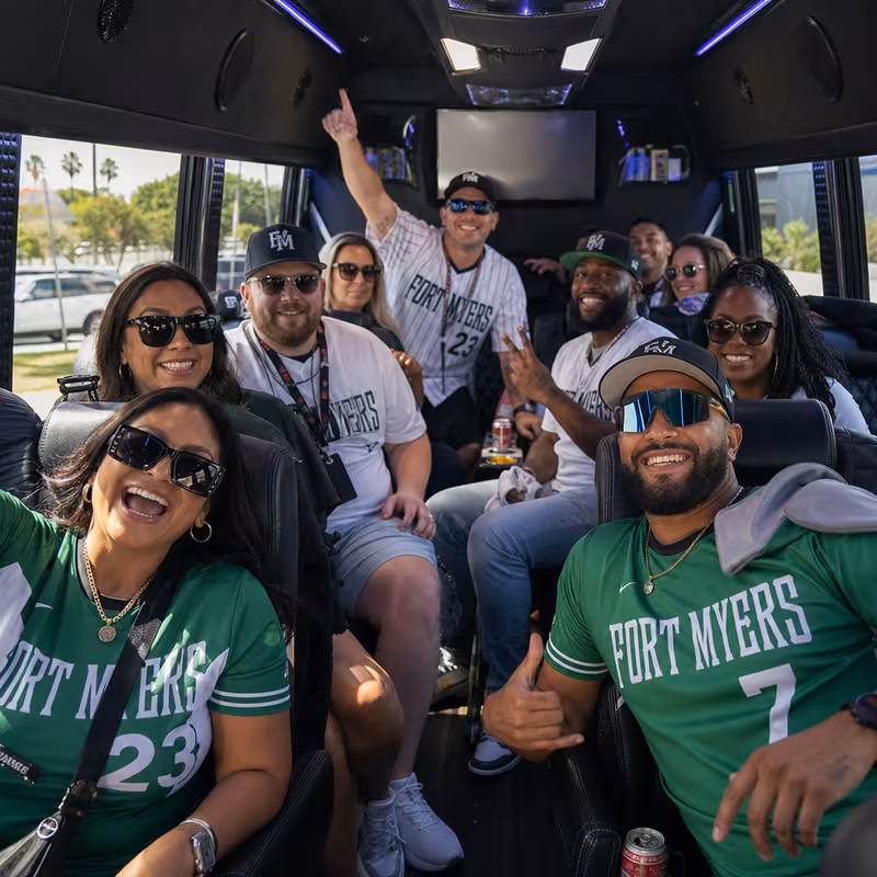 Group boarding a white charter bus for Sporting Event Transportation transportation in Fort Myers